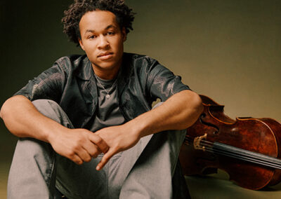 Sheku Kanneh-Mason seated with cello in the background